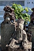 Bangkok Wat Arun - Detail of the precint of the sacred area of the ubosot with chinese noble man sitting on chair. 